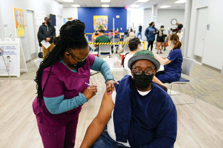 Nurse Sheena Davis administers a dose of a Moderna COVID-19 vaccine