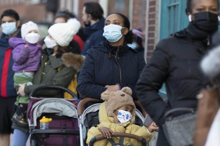 Makda Yesuf (center) and her son Jaden wait in line at a COVID-19 walk-in testing site