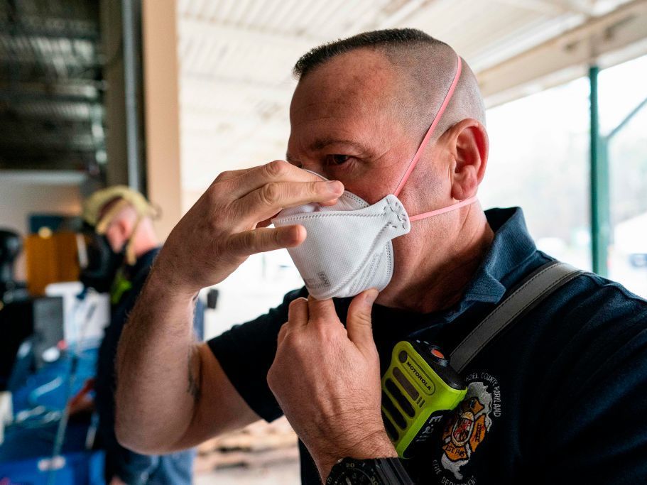 A firefighter tests the seal on his N95 mask at the start of his shift in Glen Burnie, Md. With the spread of omicron, experts say to wear high-filtration respirators in public indoors spaces for the best protection. A firefighter tests the seal on his N95 mas