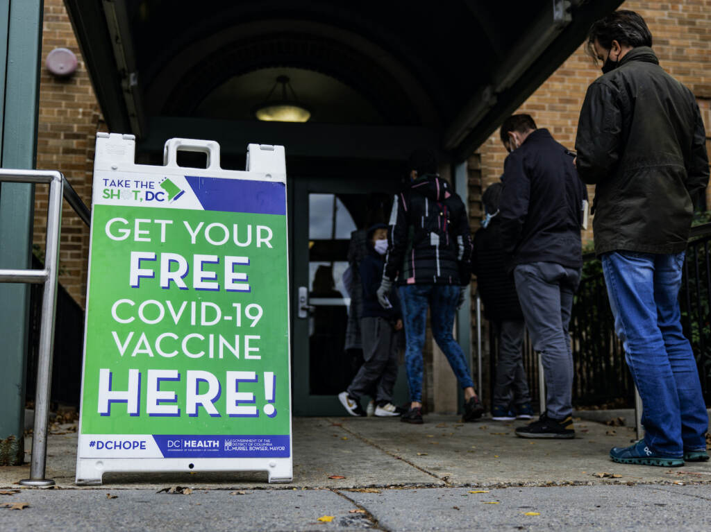 People line up outside of a free COVID-19 vaccination site