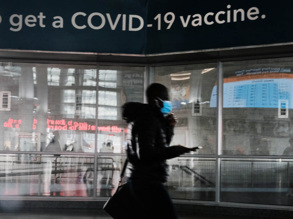 A sign urges people to get the Covid vaccine at the Staten Island Ferry terminal on November 29, 2021 in New York City. A sign urges people to get the Covid vaccine at the Staten Island Ferry terminal on November 29, 2021 in New York City. Across New York City and the nation, people are being encouraged to get either the booster shot or the Covid-19 vaccine, especially with the newly discovered omicron variant slowly emerging in countries around the world. While there are no cases yet discovered in America, New York's governor Kathy Hochul has declared a state of emergency ahead of the risk of COVID-19 spikes as winter sets in. (Photo by Spencer Platt/Getty Images)