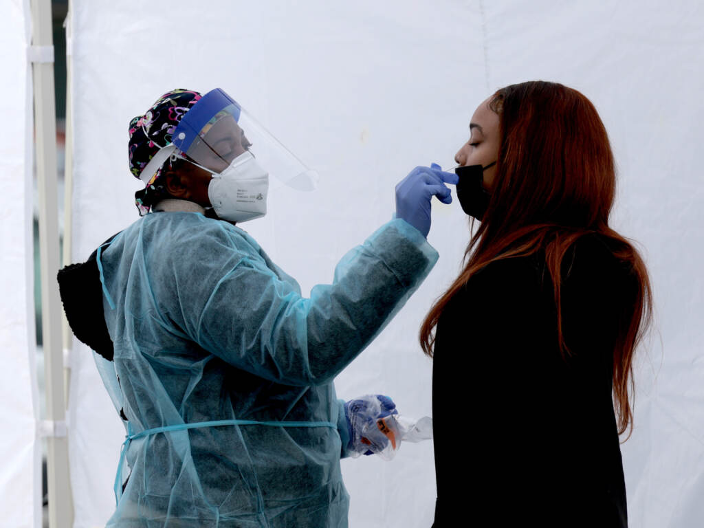 A healthcare worker administers a COVID-19 PCR test at a free test site in Farragut Square on Dec. 28 in Washington, D.C. On Tuesday, the CDC revised data reflecting the prevalence of the omicron variant in new COVID-19 cases. A healthcare worker administers a COVID-19 PCR test at a free test site in Farragut Square on December 28, 2021 in Washington, DC. (Photo by Anna Moneymaker/Getty Images)