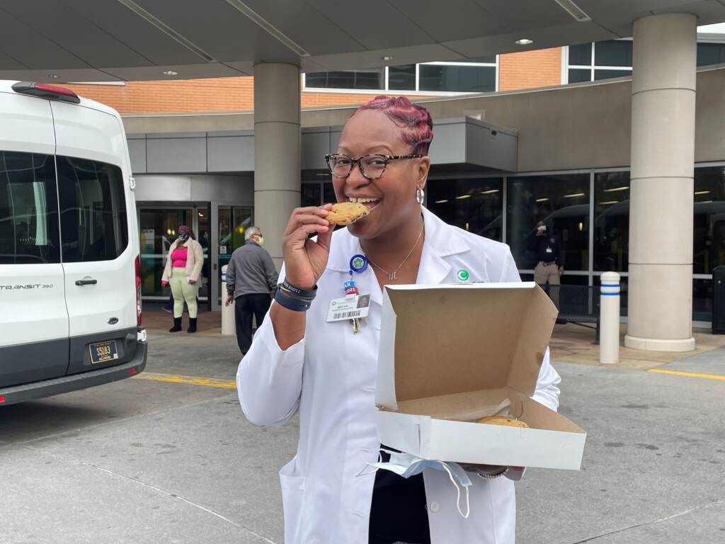 lane Nurse manager Melva Lane takes a bite of one of the chocolate chip cookies delivered by Delcastle students. (Cris Barrish/WHYY)