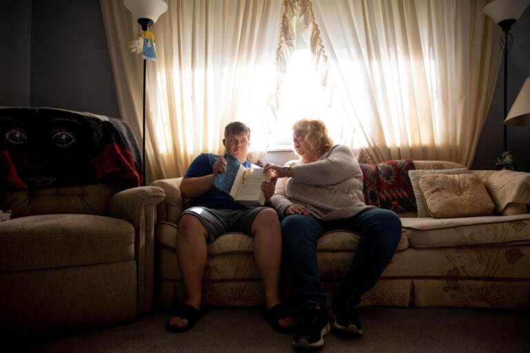 Lisa Stagon sits with her son Chris on the couch