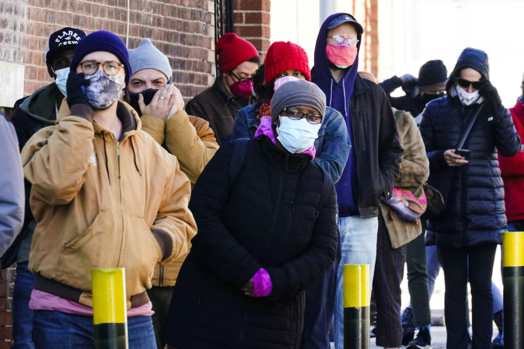 City residents wait in a line extending around the block to receive free at-home rapid COVID-19 test kits in Philadelphia