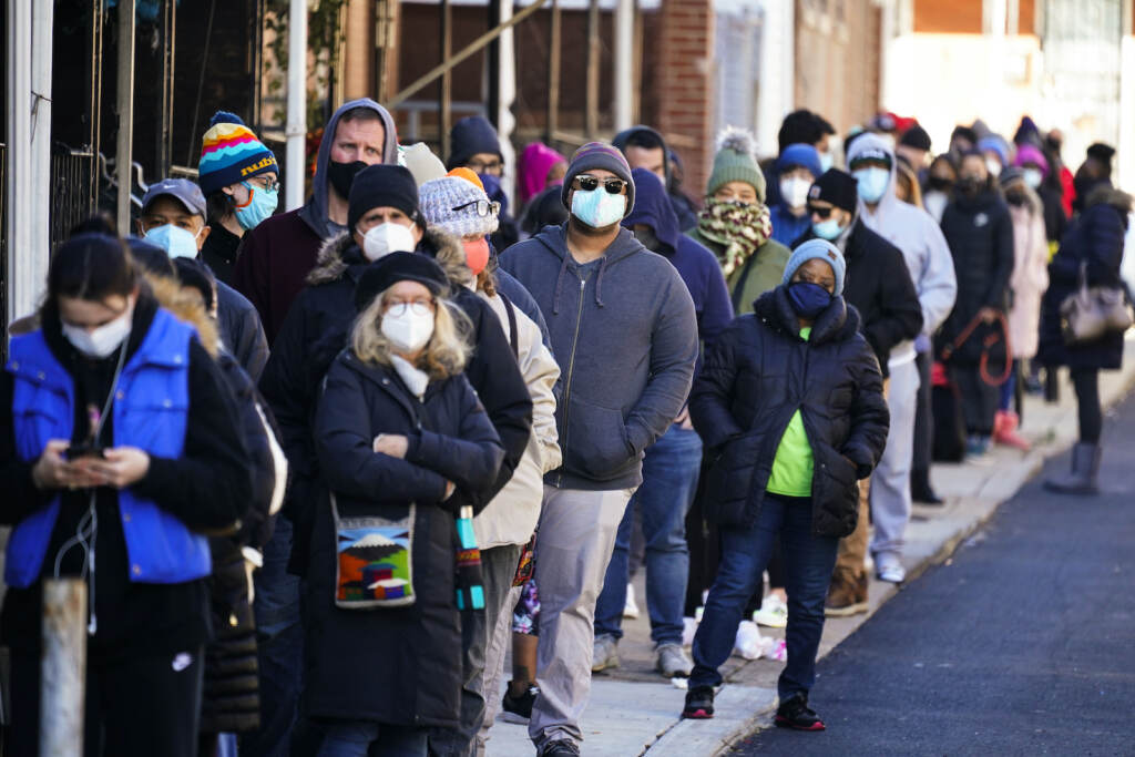 City residents wait in a line extending around the block to receive free at-home rapid COVID-19 test kits in Philadelphia