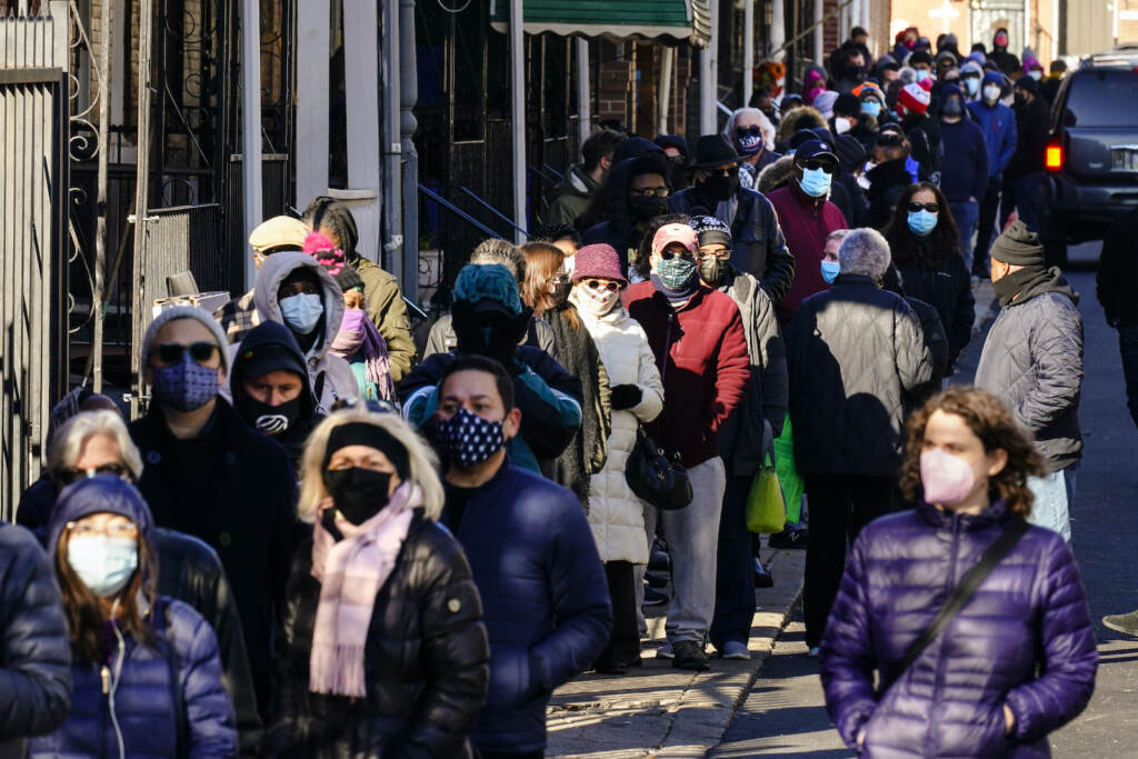 City residents wait in a line extending around the block to receive free at-home rapid COVID-19 test kits in Philadelphia