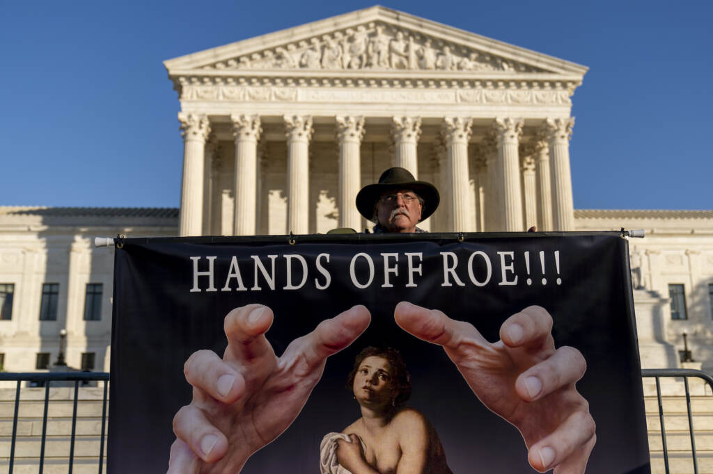 Stephen Parlato holds a sign that reads "Hands Off Roe!!!" outside the Supreme Court