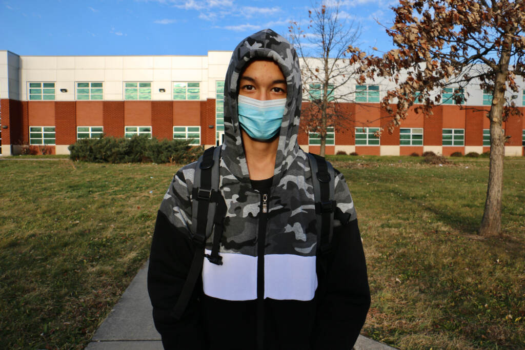 2021 12 13-e lee-ali wahaj mosakhil-philadelphia-afghan student Ali Wahaj Mosakhil wears a mask while standing in front of a school