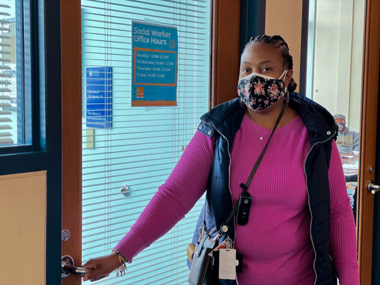 Yanna McGraw holds her hand on a doorknob while wearing a mask