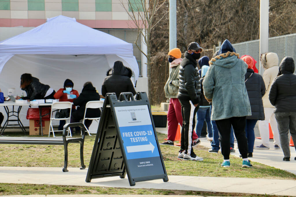 2022 01 06-e lee-philadelphia cibotti rec center-covid testing clinic tent sign line People line up for free COVID-19 tests outside Cibotti Recreation Center in Southwest Philadelphia. The clinic, operated by a testing contractor hired by the Centers for Disease Control and Prevention, will be able to test more than 500 people per day. (Emma Lee/WHYY)