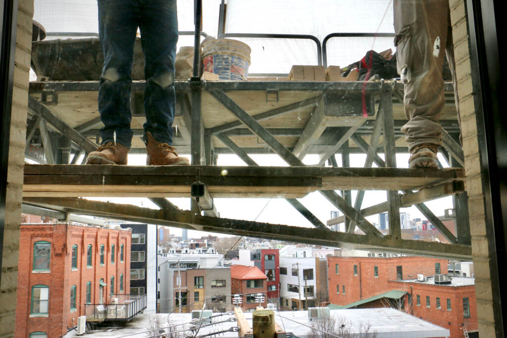 In a view from the fourth floor of the new Clay Studio in Kensington, masons apply the intricate brickwork of the facade