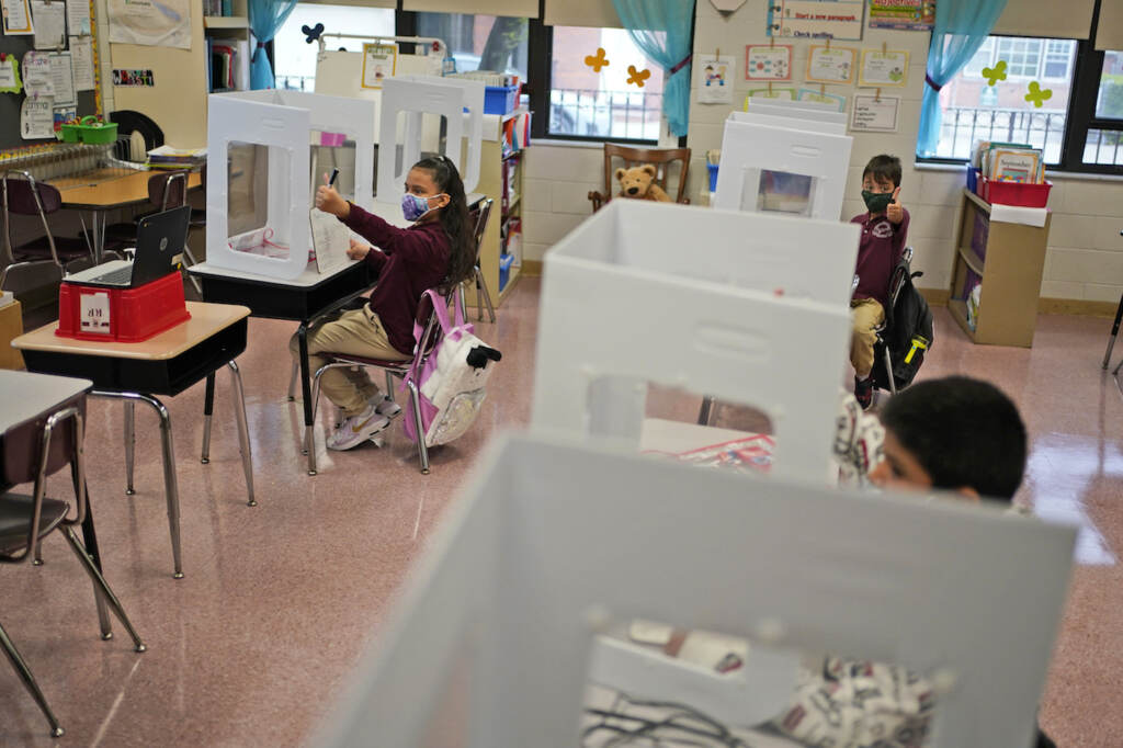 Virus Outbreak New Jersey Third graders do their work behind see-though partitions at Christa McAuliffe School in Jersey City, N.J., Thursday, April 29, 2021. (AP Photo/Seth Wenig)