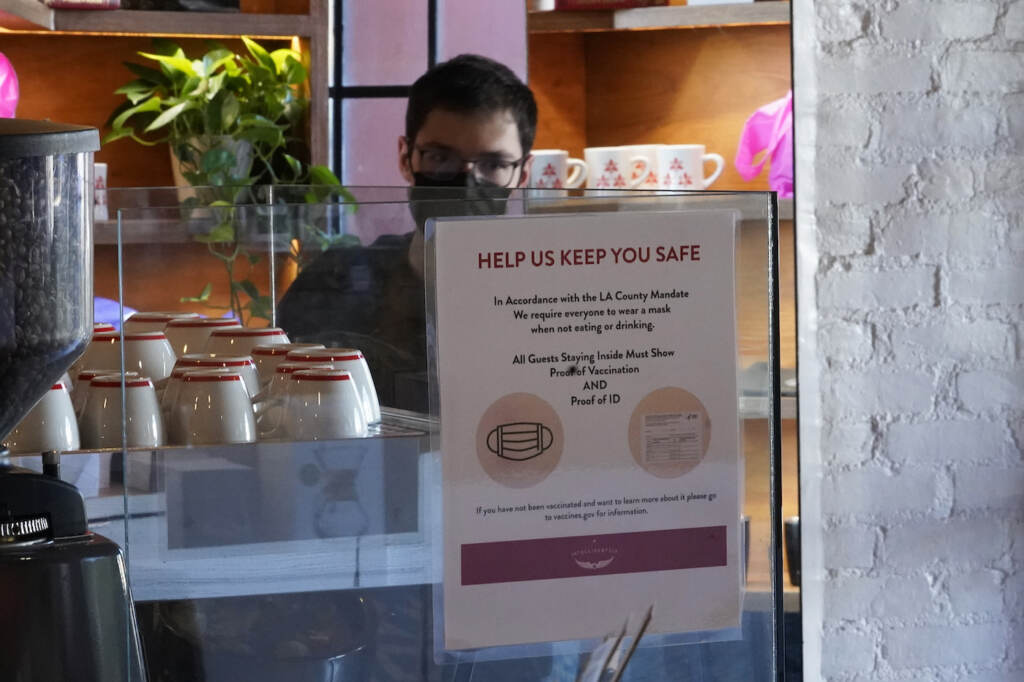 Virus Outbreak California A sign explaining the LA County Mandate is posted for customers inside the Intelligentsia Coffee in Sunset Blvd., coffee shop in Los Angeles, Monday, Nov. 29, 2021. (AP Photo/Damian Dovarganes)