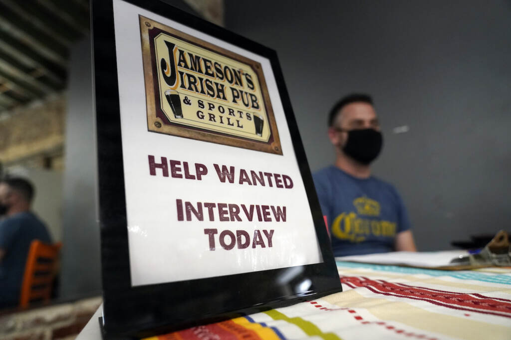 California Jobs FILE - A hiring sign is shown at a booth for Jameson's Irish Pub during a job fair on Sept. 22, 2021, in the West Hollywood section of Los Angeles. Hiring in California slowed significantly in November 2021 even as the state's unemployment rate dipped below 7% for the first time since March 2020, at the start of the pandemic, according to data made public Friday, Dec. 17, 2021. (AP Photo/Marcio Jose Sanchez, File)