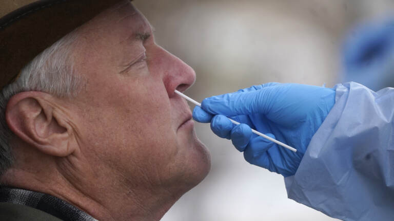 A member of the Salt Lake County Health Department COVID-19 testing staff performs a test on Gary Mackelprang outside the Salt Lake County Health Department Tuesday, Jan. 4, 2022, in Salt Lake City