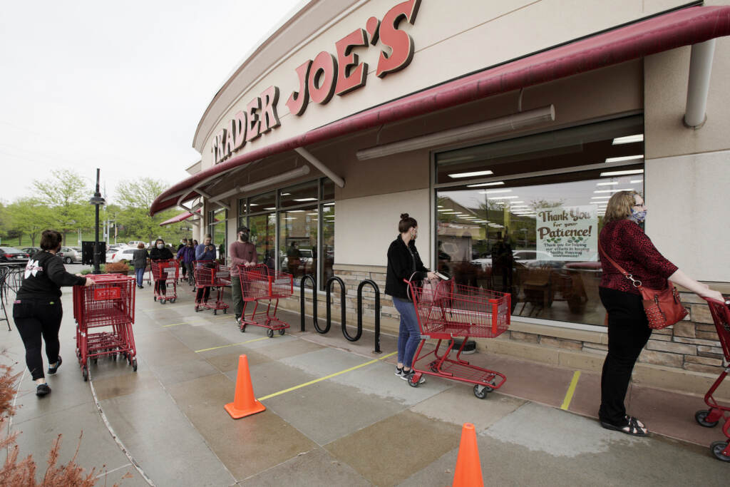 Virus Outbreak Sick Leave Customers observe social distancing as they wait to be allowed to shop at a Trader Joe's supermarket in Omaha, Neb., Thursday, May 7, 2020. Store workers across the country are suddenly being asked to enforce the rules that govern shopping during the coronavirus pandemic.(AP Photo/Nati Harnik)