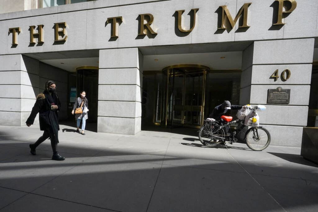 Trump Legal Troubles FILE - Pedestrians and a food delivery man are seen outside the Trump building at 40 Wall Street in New York's Financial District, Tuesday, March 23, 2021. The New York attorney general, Tuesday, Jan. 18, 2022, says her investigators have uncovered evidence that former President Donald Trump's company used 'fraudulent or misleading' valuations of its golf clubs, skyscrapers and other property to get loans and tax benefits. (AP Photo/Mary Altaffer)