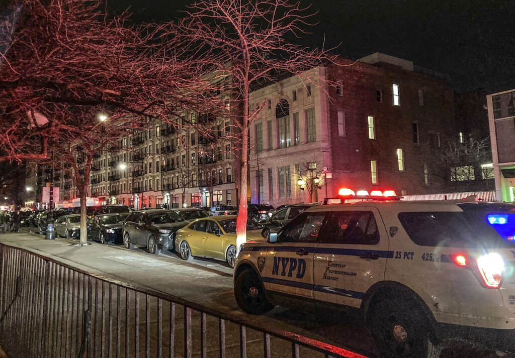 Police Officers Shot Police secure the scene outside a six story residential building, left, where two NYPD officers where shot responding to a domestic disturbance call in Harlem, Friday Jan. 21, 2022, in New York