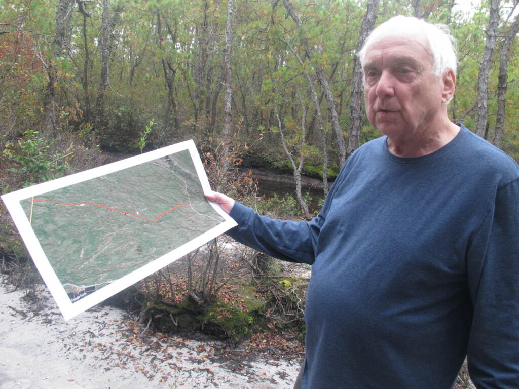 Albert Horner holds a map of areas that have sustained damage from illegal vehicle use