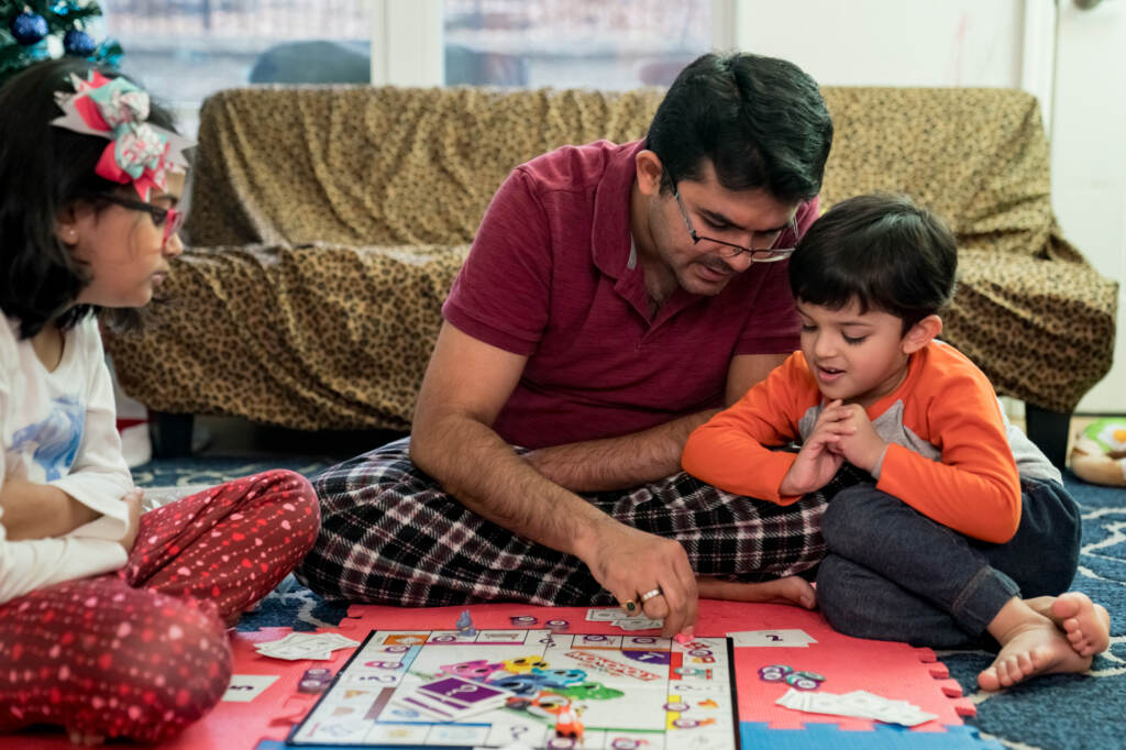 Dhaval Bhatt plays Monopoly with his children, Hridaya (left) and Martand, at their home in St. Peters, Missouri. Martand’s mother took him to a children’s hospital in April after he burned his hand, and the bill for the emergency room visit was more than $1,000 — even though the child was never seen by a doctor. Dhaval Bhatt plays Monopoly with his children, Rhidya (left) and Martand, at their home in St. Peters, Missouri. Martand's mother took him to a children's hospital in April after he burned his hand, and the bill for the emergency room visit was more than $1,000 — even though the child was never seen by a doctor. (Whitney Curtis for KHN)