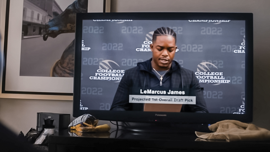 Actor Stephan James portraying football player LeMarcus James giving a press conference on TV in the movie National Champions