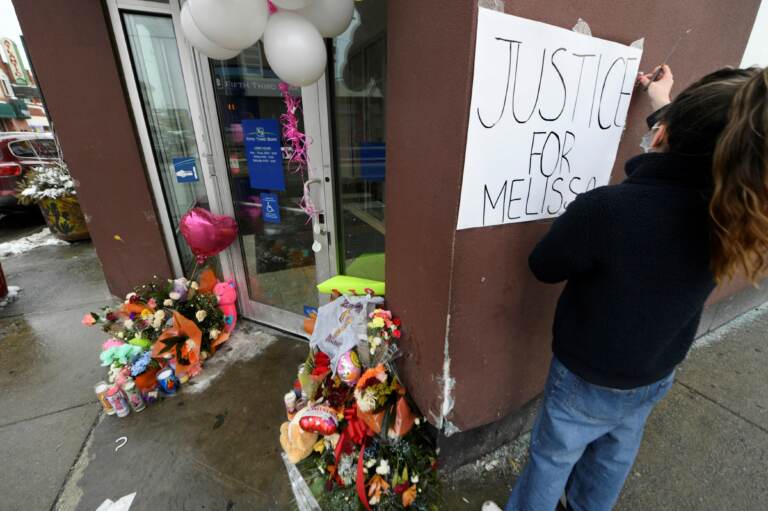Karla Chavez, of the social activist group Chiactivists, puts up a sign at a memorial for 8 year old Melissa Ortega in Chicago on January 24, 2022. - Ortega was walking with her mother in Chicago's Little Village neighborhood on January 22 when she was struck by stray bullets after an unknown offender shot multiple times in their direction. (Photo by Paul Beaty / AFP) (Photo by PAUL BEATY/AFP via Getty Images)