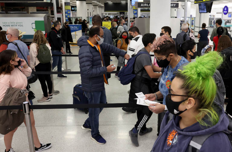 MIAMI, FLORIDA - DECEMBER 28:  Travelers make their way through Miami International Airport on December 28, 2021 in Miami, Florida. Over the holiday weekend, COVID-19 cases in the U.S. reached their highest level in nearly a year. More than 2,000 flights were canceled over the weekend as airlines dealt with a surge in COVID-19 cases due to the Omicron variant. (Photo by Joe Raedle/Getty Images)