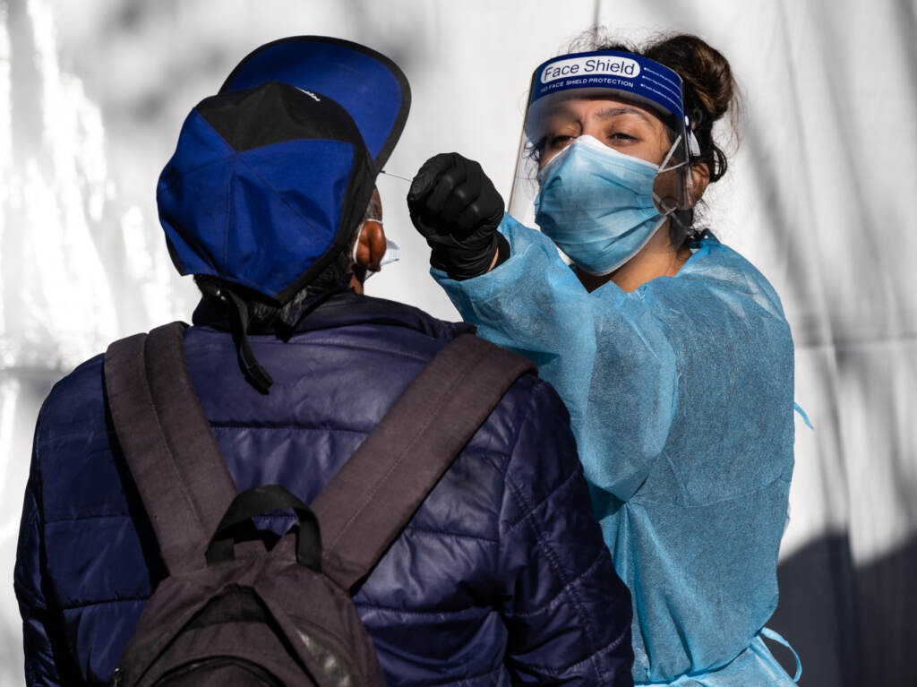 As demand for testing ramps up, community clinics and nonprofits struggle to keep up with the need. These groups have run testing sites throughout the pandemic in low-income and minority neighborhoods, like this one in the Mission District of San Francisco, Calif., from UCSF and the Latino Task Force. A health care worker administers a test at a Covid-19 testing tent outside a Bay Area Rapid Transit (BART) station in the Mission District of San Francisco, California, U.S., on Monday, Nov. 30, 2020. UCSF and the Latino Task Force held post-holiday Covid-19 testing in four of the most affected neighborhoods in San Francisco, ABC7 San Francisco reports. Photographer: David Odisho/Bloomberg via Getty Images
