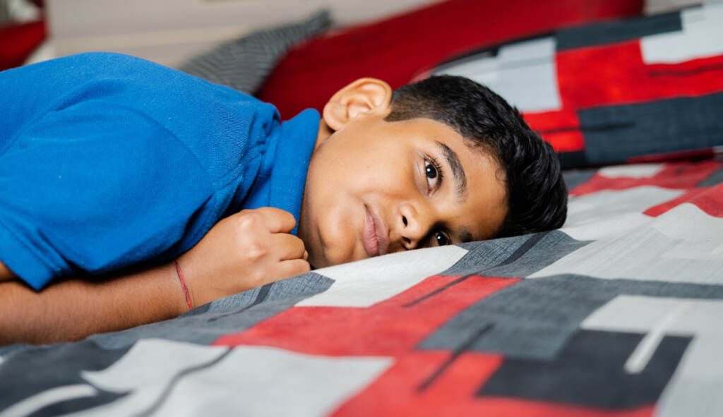 voices-bigstock-Crying-Angry-Kid-On-Bed-By-Wit-444407108 A child crying and anxious lying down on a blanket