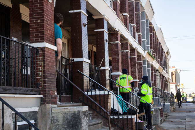 The Philadelphia Water Department knocked on doors on South 56th Street to inform residents that their gas and water had been shut off after a water main break at 56th and Springfield Avenue in West Philadelphia on Feb. 9, 2022. (Kimberly Paynter/WHYY)