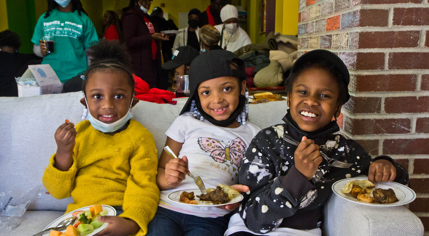 Asiah Smith, 4 (left), Zara Johnson, 6 (center), and Aliyah Sanders, 8 (right), enjoy a meal at The Teen Safe Space’s opening day. (Kimberly Paynter/WHYY)