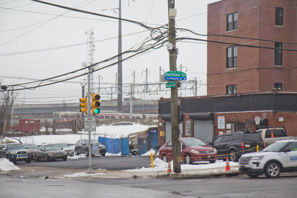A regional rail SEPTA train passes a building in Germantown
