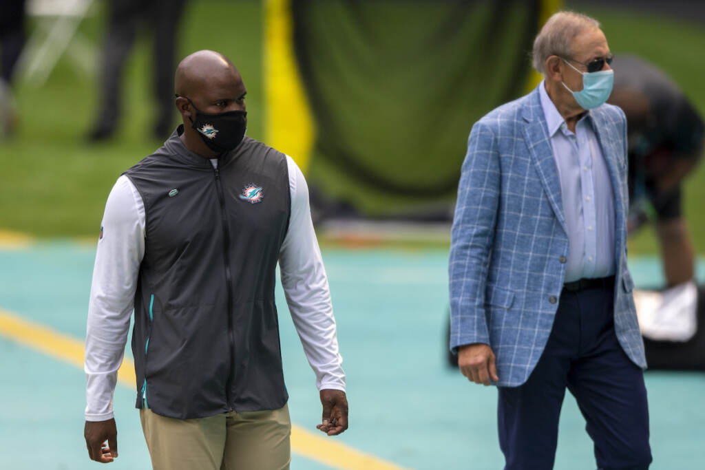 Miami Dolphins head coach Brian Flores and Miami Dolphins owner Stephen Ross wearing masks on the sidelines before taking on the Seattle Seahawks during an NFL football game, Sunday, Oct. 4, 2020, in Miami Gardens, Fla. (AP Photo/Doug Murray)