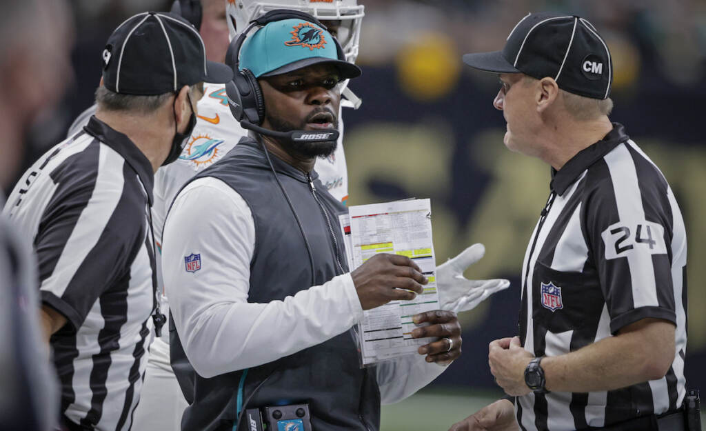 Brian Flores, David Oliver File photo: Miami Dolphins head coach Brian Flores, center, talks to down judge David Oliver (24) during the first half of an NFL football game against the New Orleans Saints Monday, Dec. 27, 2021, in New Orleans. Fired Miami Dolphins Coach Brian Flores sued the NFL and three of its teams Tuesday, Feb. 1, 2022 saying racist hiring practices by the league have left it racially segregated and managed like a plantation