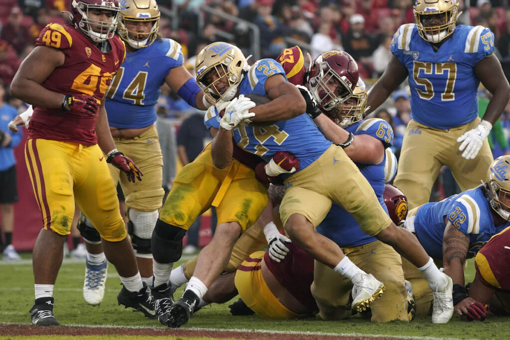 File photo: UCLA running back Zach Charbonnet (24) runs the ball in for a touch down as Southern California defensive lineman Jacob Lichtenstein (97) tries to stop him during the second half of an NCAA college football game Saturday, Nov. 20, 2021, in Los Angeles. An advocacy group for college athletes has filed a complaint with the National Labor Relations board in the next step in a push to give employee status to college athletes and afford them the right to competitive pay, collective bargaining and other benefits and protections. The National College Players Association on Tuesday, Feb. 8, 2022 filed the unfair labor practice charges against the NCAA, Pac-12 Conference, UCLA and the University of Southern California