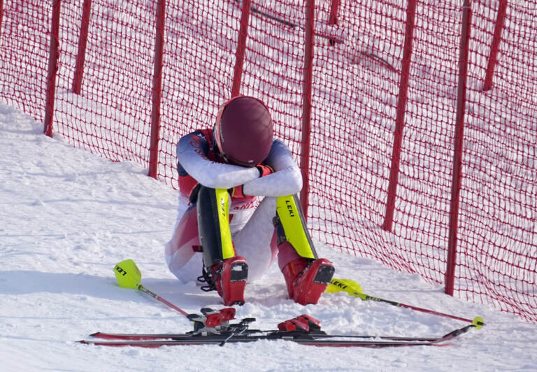 Mikaela Shiffrin, of the United States sits on the side of the course after skiing out in the first run of the women’s slalom at the 2022 Winter Olympics, Wednesday, Feb. 9, 2022, in the Yanqing district of Beijing