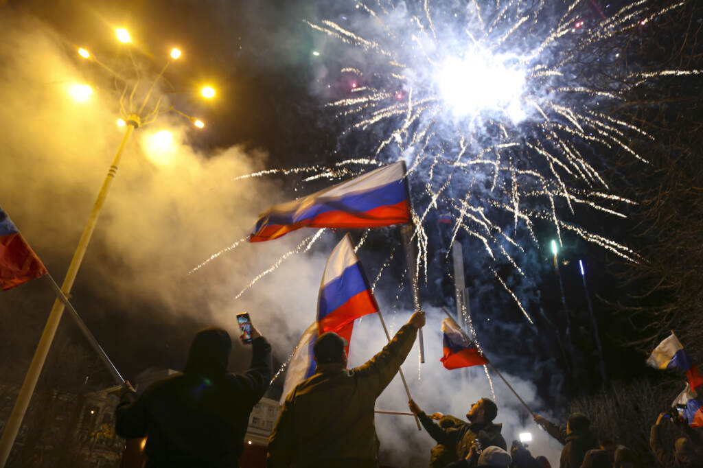 APTOPIX Ukraine Tensions People wave Russian national flags celebrating the recognizing the independence in the center of Donetsk, the territory controlled by pro-Russian militants, eastern Ukraine, late Monday, Feb. 21, 2022. In a fast-moving political theater, Russian President Vladimir Putin has moved quickly to recognize the independence of separatist regions in eastern Ukraine in a show of defiance against the West amid fears of Russian invasion in Ukraine. (AP Photo/Alexei Alexandrov)