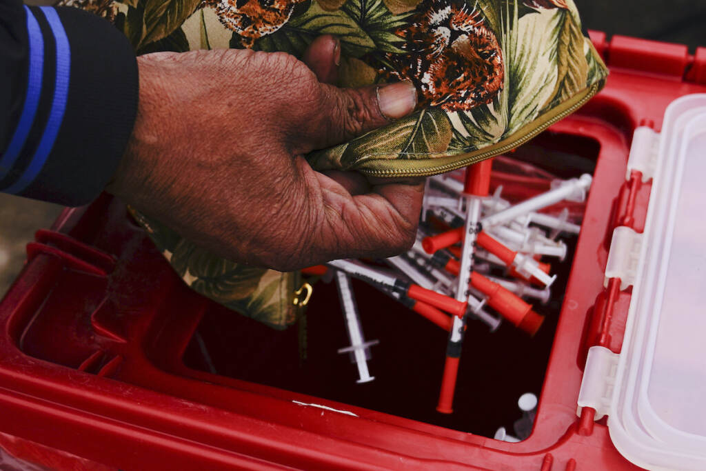 Opioid Crisis Settlement Keith Lewis disposes of used syringes at a needle exchange run by Camden Area Health Education Center in Camden, N.J., Thursday, Feb. 24, 2022. (AP Photo/Matt Rourke)