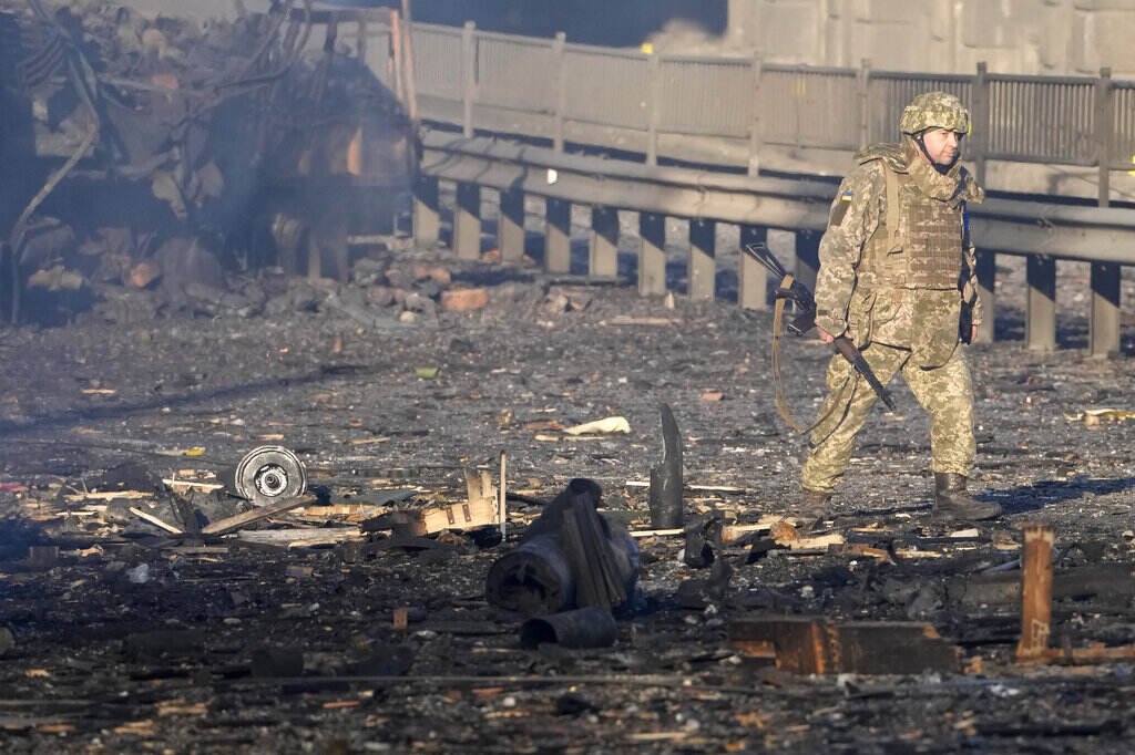 Ukraine Invasion A Ukrainian soldier walks past debris of a burning military truck, on a street in Kyiv, Ukraine, Saturday, Feb. 26, 2022. Russian troops stormed toward Ukraine's capital Saturday, and street fighting broke out as city officials urged residents to take shelter. (AP Photo/Efrem Lukatsky)