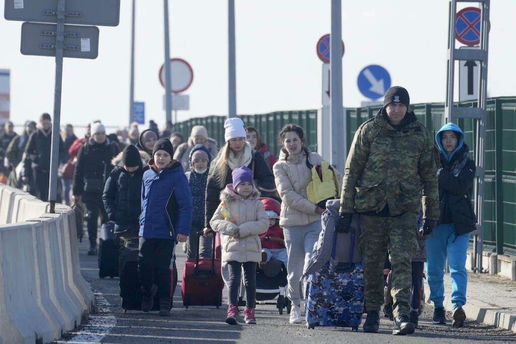 APTOPIX Poland Ukraine Invasion A Polish border guard assists refugees from Ukraine as they arrive to Poland at the Korczowa border crossing, Poland, Saturday, Feb. 26, 2022