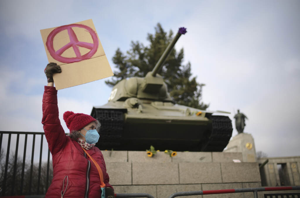 Ukraine Invasion Germany U Turn A woman shows a peace sign in front of a Russian WWII tank at the Soviet War Memorial at the bolevard 'Strasse des 17. Juni' alongside a rally against Russia's invasion of Ukraine in Berlin, Germany, Sunday, Feb. 27, 2022. (AP Photo/Markus Schreiber)