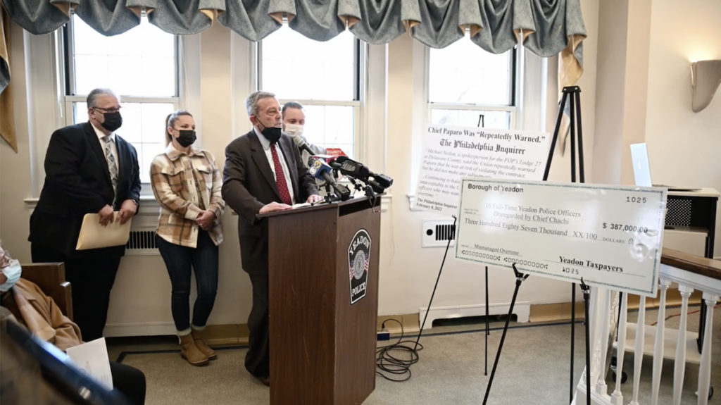An angry member of the public bashes council members for their placement of signs, such as the giant check, near the podium. An angry member of the public criticizes council members for their placement of signs, such as the giant check, near the podium. (Kenny Cooper/WHYY)