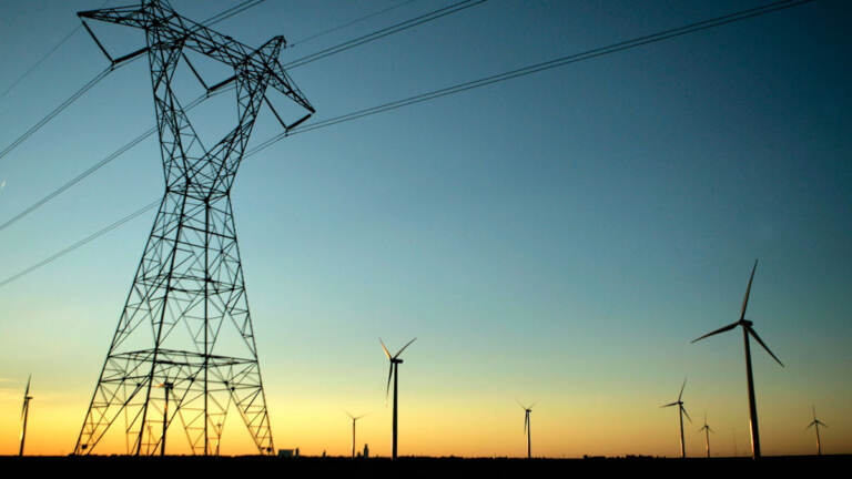 High-voltage electric transmission lines pass through a wind farm.
