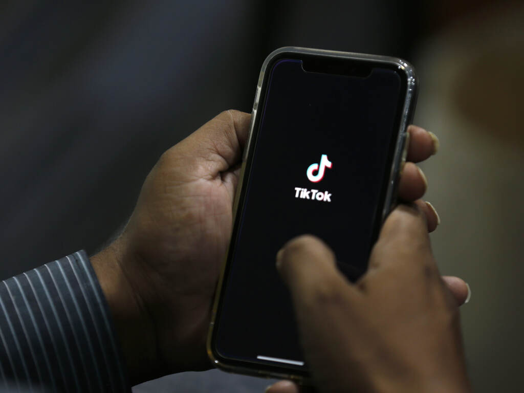 In this July 21, 2020 file photo, a man opens social media app ‘TikTok’ on his cell phone. TikTok announced an update to its community guidelines to ban deadnaming, misgendering and misogyny. (Anjum Naveed/AP)