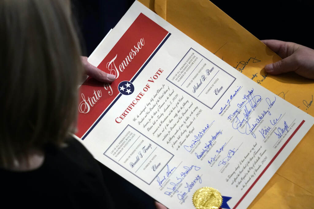Staff members hold the certification of Electoral College votes from Tennessee