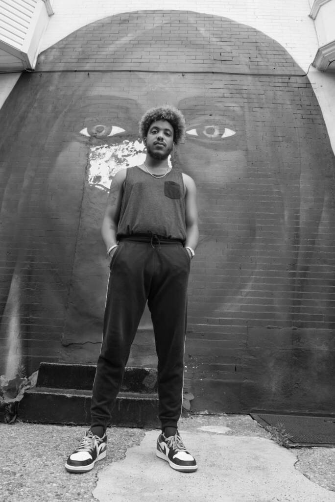 Eli Cappella is seen standing in front of a mural in Philly