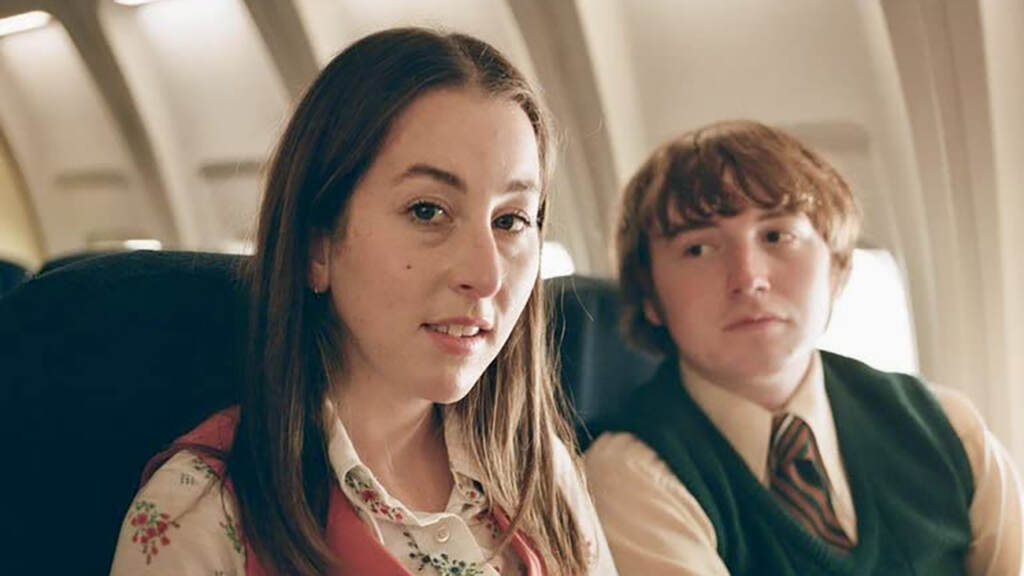 flicks-licorice-pizza Cooper Hoffman and Alana Haim sitting on a plane in Licorice Pizza