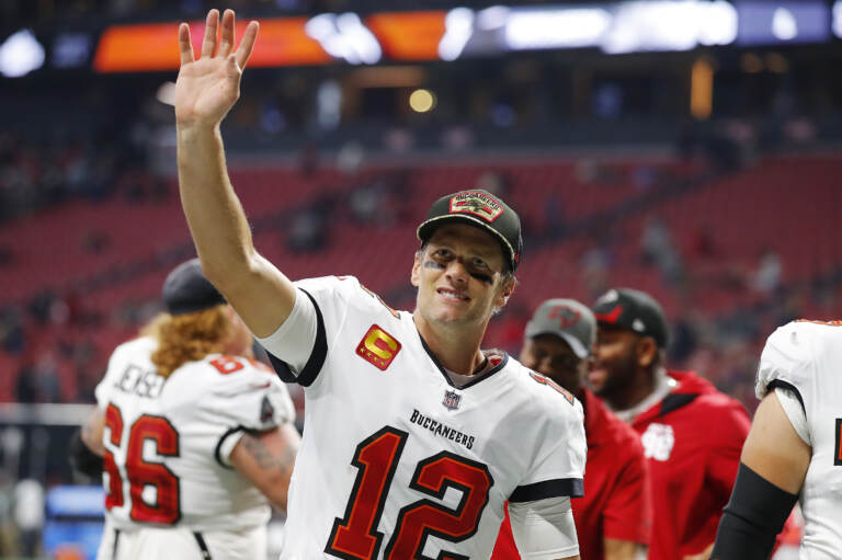 Tom Brady throws his hand up in the air