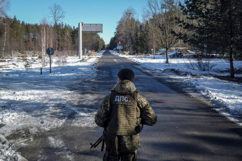 A member of the Ukrainian State Border Guard stands watch at the border crossing between Ukraine and Belarus on Saturday. A member of the Ukrainian State Border Guard stands watch at the border crossing between Ukraine and Belarus on Saturday. (Chris McGrath/Getty Images)